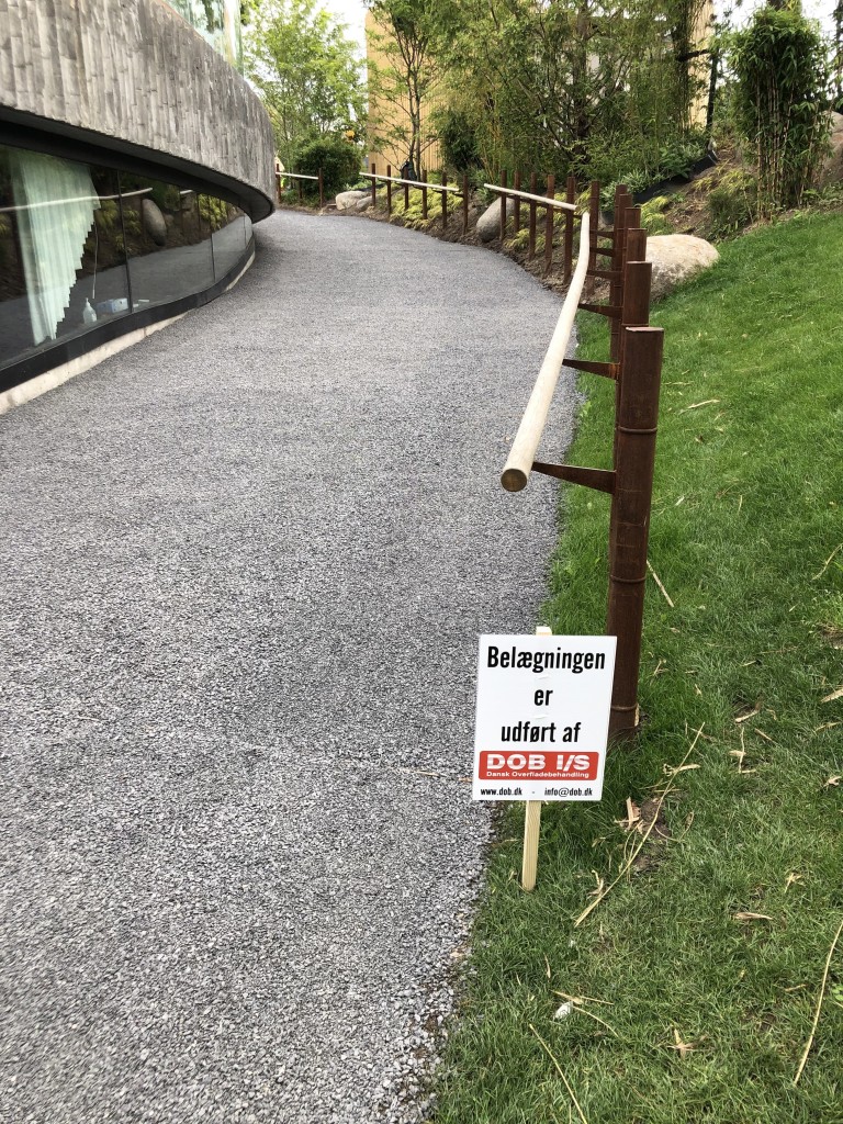 Pandaanlæg med sort belægning på zoo stier